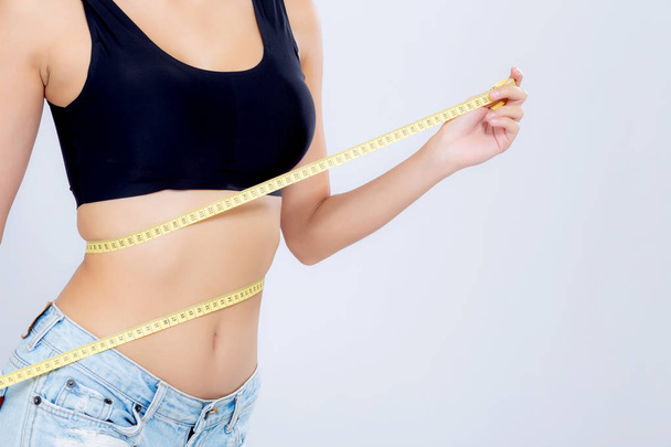 Aziatische vrouw dieet en slank met het meten van de taille voor gewicht isolat - Foto, afbeelding