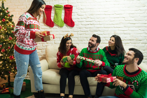Захоплені друзі з сюрпризними подарунками вдома під час різдвяних святкувань
 - Фото, зображення