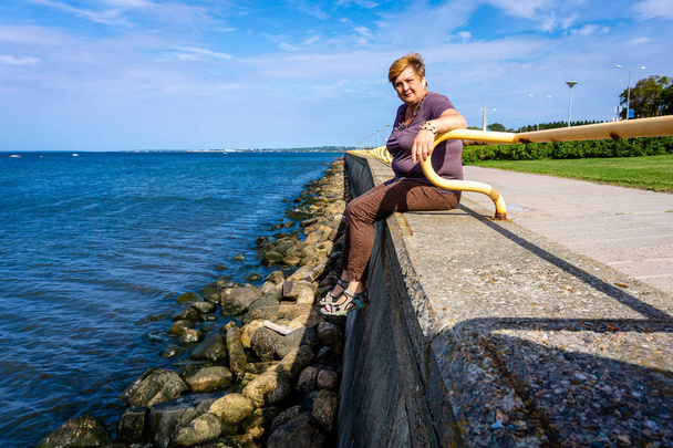 Femme mûre reposant sur la côte de la mer
. - Photo, image