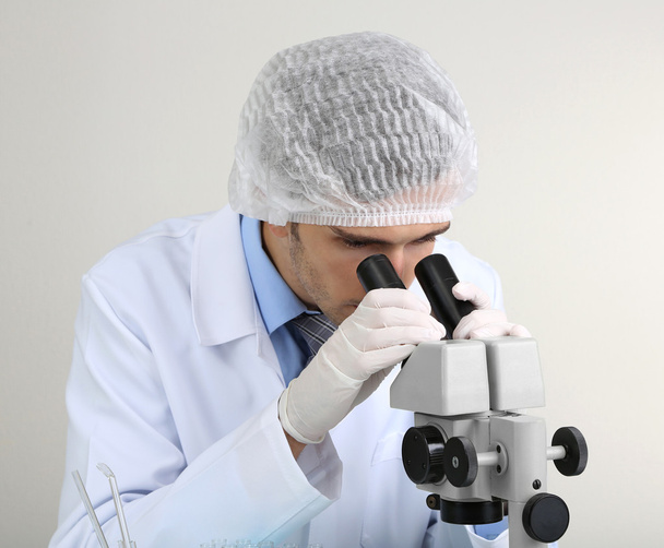 Young laboratory scientist looking at microscope in lab - Foto, Imagem