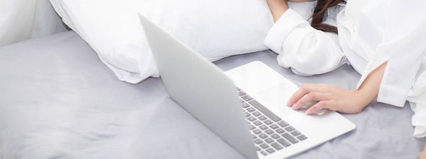 Bannière site belle jeune femme asiatique avec ordinateur portable couché dow
 - Photo, image
