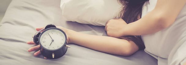 Banner website closeup asian young woman turn off alarm clock in - Photo, Image