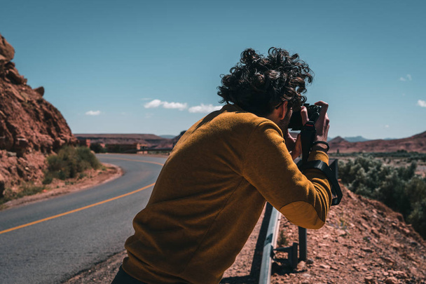 Man with yellow sweater taking picture in the mountains - Foto, Imagem
