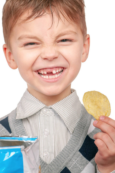 O rapazinho está a comer batatas fritas
 - Foto, Imagem