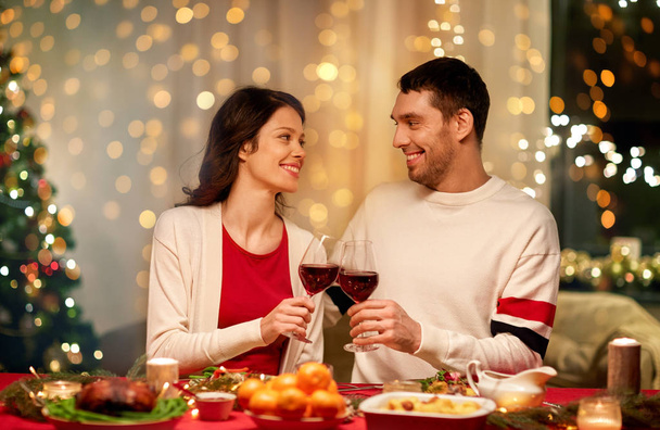 happy couple drinking red wine at christmas dinner - Photo, image