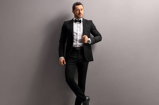 Elegant young man in a black suit and bow tie - Фото, зображення