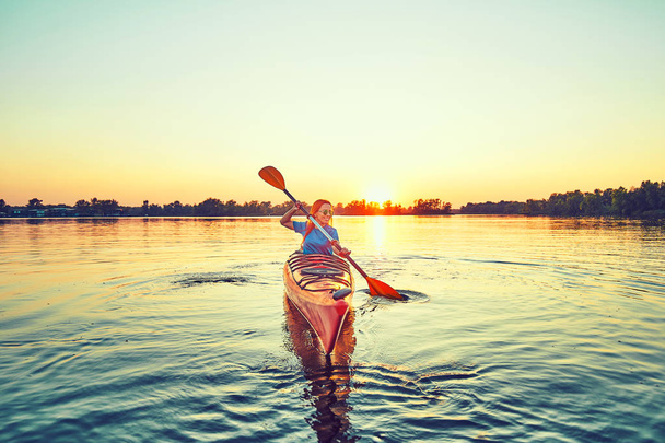 People kayak during sunset in the background. Have fun in your f - Foto, imagen