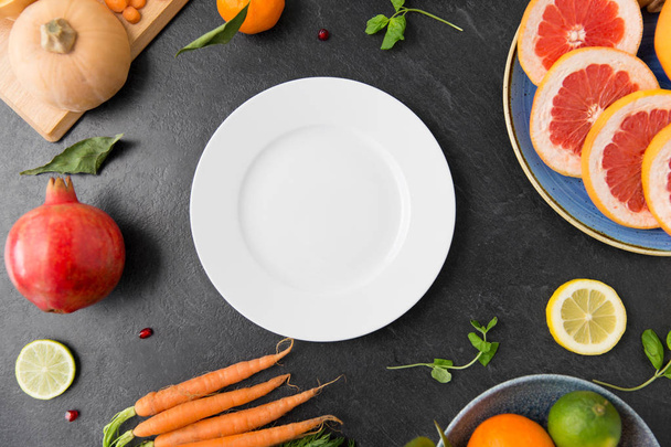 plate, vegetables and fruits on on slate table - Zdjęcie, obraz