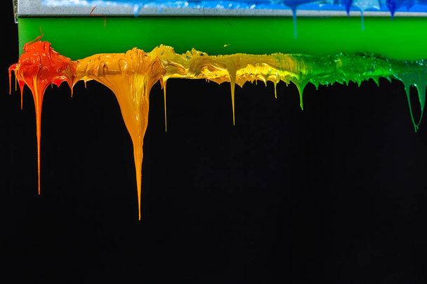 varios colores de goteo tinta en impresoras mango en la fábrica de camisetas cuelgan en el almacenamiento
 - Foto, imagen