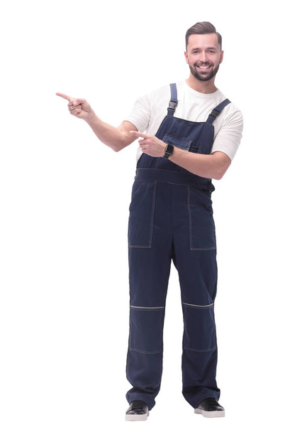 smiling man in overalls pointing to a copy of the space - Foto, imagen