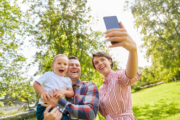 gelukkig familie nemen selfie in zomer park - Foto, afbeelding