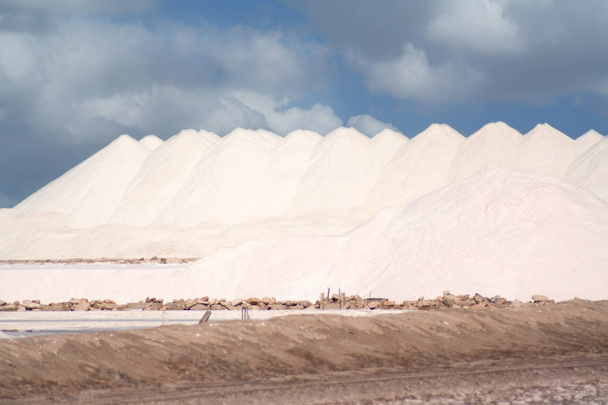 Виробництво солі. Соляні гори на тлі блакитного неба
. - Фото, зображення