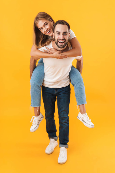 Image of excited couple smiling together while doing piggyback ride - Photo, image