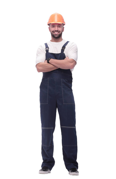 in full growth. smiling man in overalls and a safety helmet - Фото, изображение