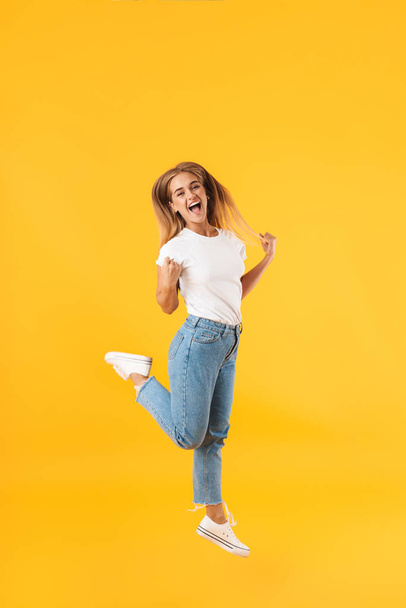 Full length image of amazed woman jumping and screaming like win - Фото, изображение