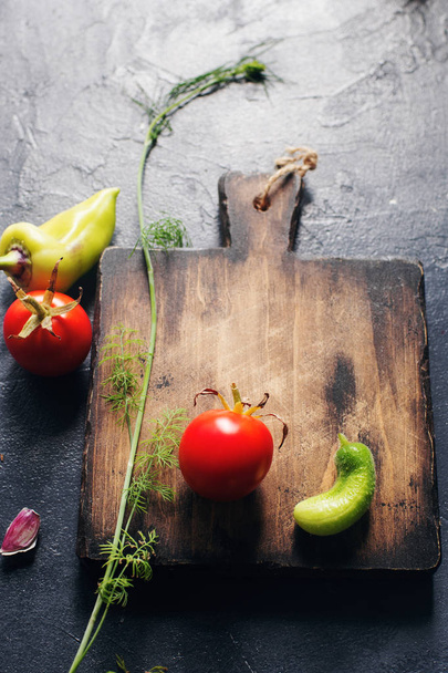 Raw fresh fruits and vegetables around rustic wooden cutting board  - Φωτογραφία, εικόνα