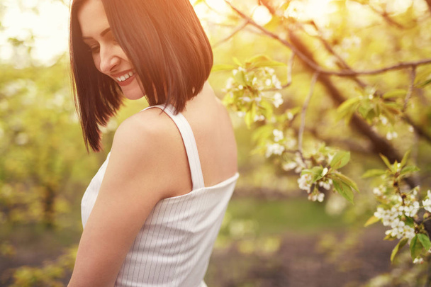 Carefree woman walking along blossoming garden - Fotografie, Obrázek