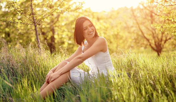 Femme joyeuse relaxant sur l'herbe dans la nature
 - Photo, image