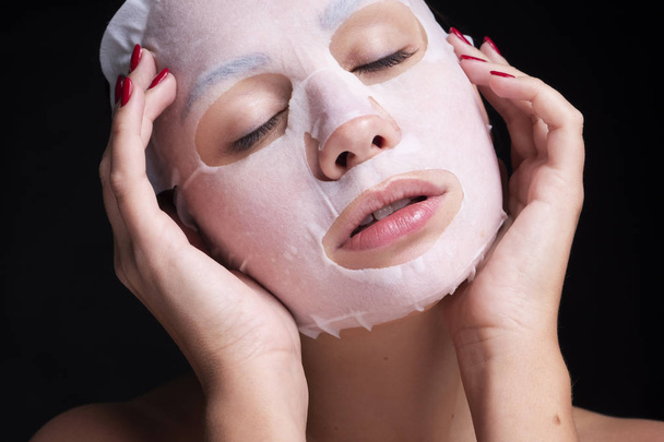 Beautiful young european woman apply clay mask on her face. beau - Foto, Bild