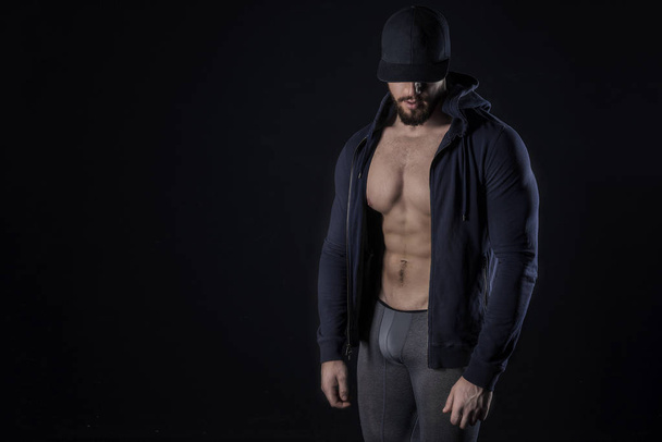 Atletisch Sterke Seksuele Man Abs Six Pack spieren Bodybuilding en Fitness Concept. Studio shot, Low key, kopieer ruimte op zwarte achtergrond - Foto, afbeelding