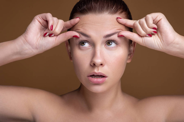 Brunette caucasian woman squeeze acne. Close up portrait of face - Photo, image