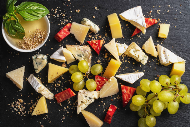 Set de quesos. Brie fresco, gorgonzola, parmesano, surtido de camembert. Menú del restaurante sobre fondo negro
 - Foto, Imagen