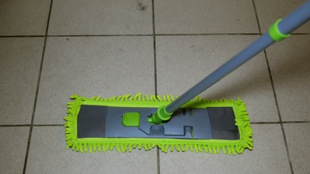 Domácí život. Dlaždicové čištění podlahy používá moderní plochý mop s pohodlným otáčejícím se držadli. Koncept domácí práce. Close-up. - Záběry, video
