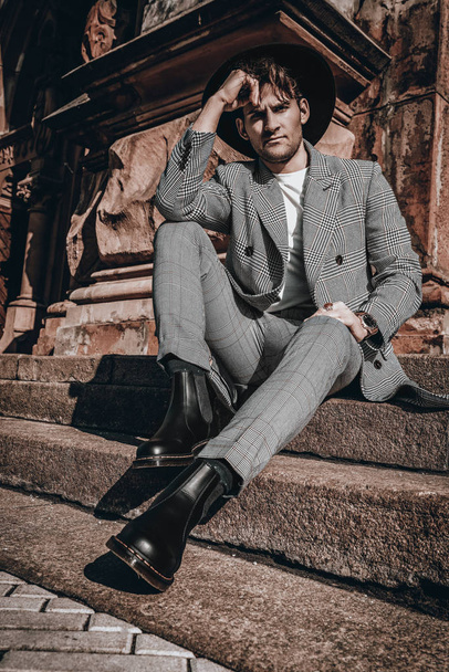 junger stylischer bärtiger Mann mit urbanem Hintergrund in lässigem Mantel. trendige gut aussehende Mode Kerl Porträt in der Stadt Straße - Foto, Bild