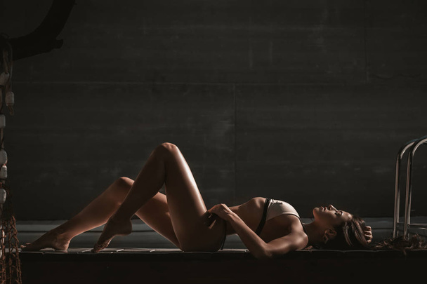 Retrato quente de mulher bonita posando na piscina em roupa interior ou maiô. Modelo morena atraente com corpo magro em lingerie
 - Foto, Imagem