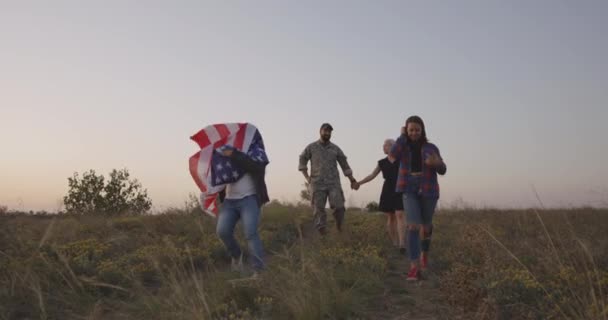 Żołnierz i jego rodzina chodzą na łące - Materiał filmowy, wideo