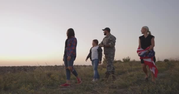 Ο στρατιώτης και η οικογένειά του περπατούν σε ένα λιβάδι - Πλάνα, βίντεο