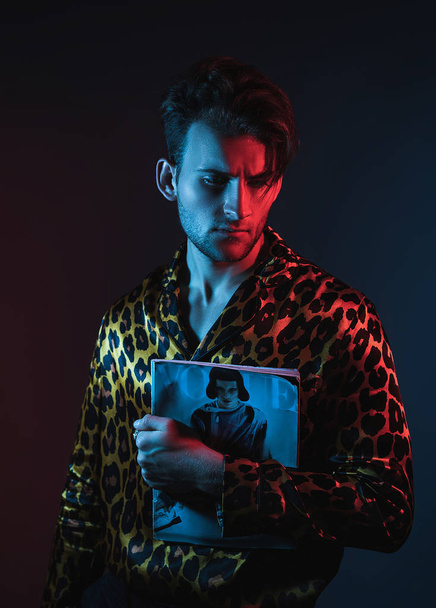 Neon licht studio portret van knappe man model in luipaard shirt. Glamour. - Foto, afbeelding