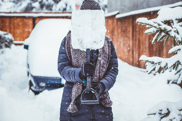 femme avec pelle nettoyage neige aeound voiture. Pelle d'hiver. Objet :
 - Photo, image