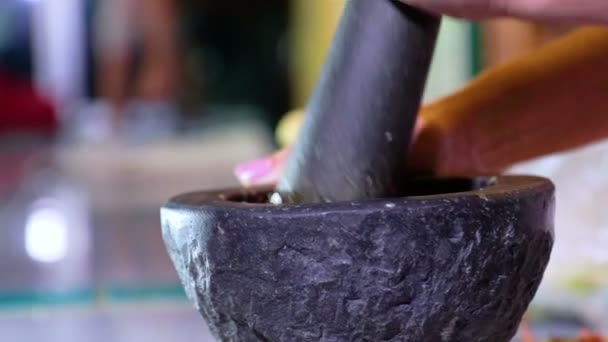 De vrouwen beukende specerijen en kruiden in mortel voor het koken van voedsel, houden stamper met mortel en Spice pasta van Thais populair eten - Video