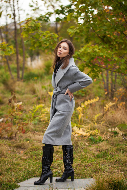 Portrait of young beautiful woman in gray coat posing in autumn  - Фото, изображение