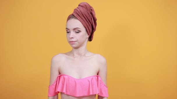 fiatal lány törölköző a feje fölött elkülönített narancssárga háttér mutatja érzelmek - Felvétel, videó