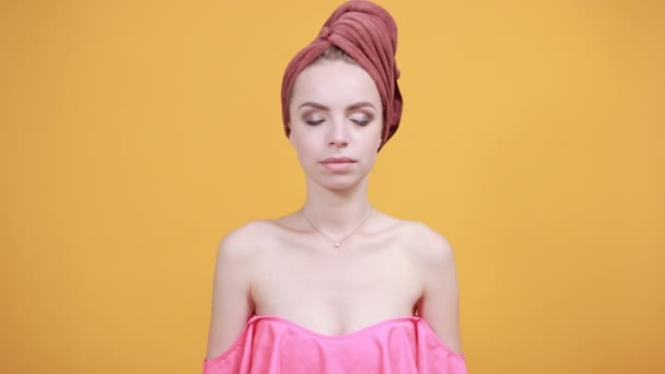 chica joven con toalla en la cabeza sobre fondo naranja aislado muestra emociones
 - Metraje, vídeo