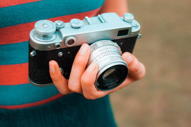 Une jeune femme porte une caméra vintage en plein air
 - Photo, image