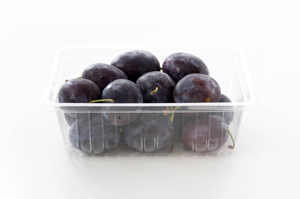 Čerstvé fialové švestky v plastovém potravinovém boxu - Fotografie, Obrázek