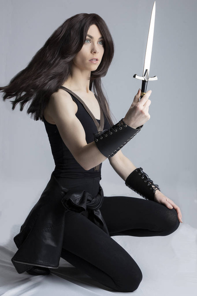 Elf-like woman in fantasy style pose holding a dagger - Photo, image
