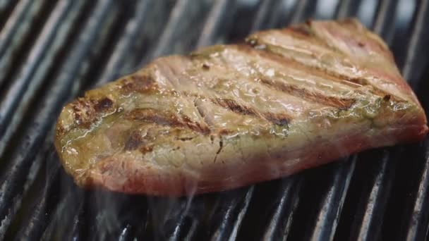 Delicious juicy meat steaks cooking on the grill - 映像、動画