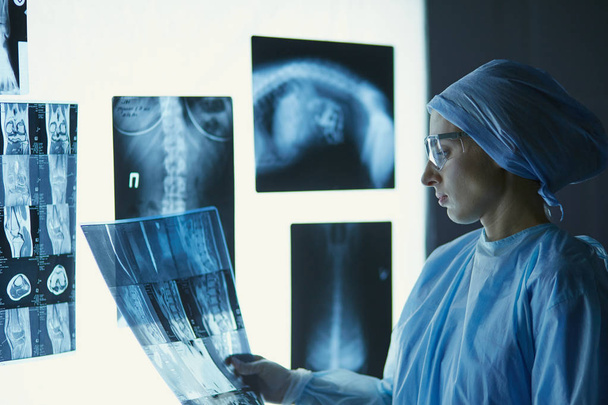 Две женщины-медики смотрят на рентгеновские снимки в больнице
 - Фото, изображение