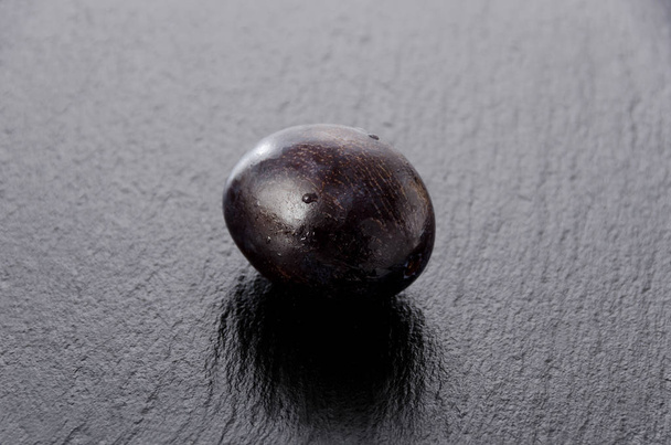 Prunes pourpres fraîches sur plaque de pierre noire
 - Photo, image