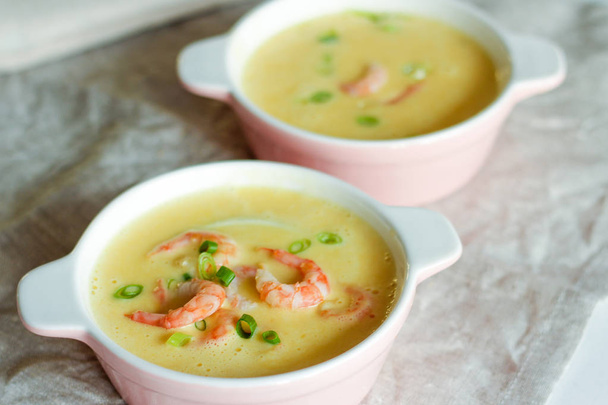 Вкусный суп со свежими креветками на столе
 - Фото, изображение