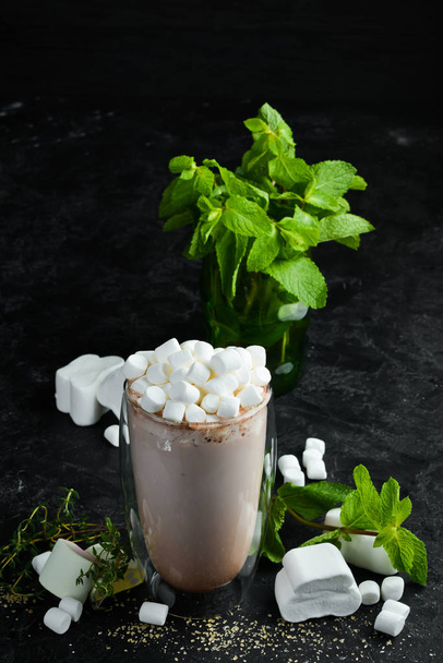 Cocoa with milk and marshmallows. In the glass. Top view. On a black background. - Фото, изображение
