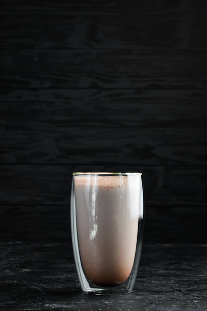 Cocoa with caramel and milk. In the glass. Top view. On a black background. - Photo, Image