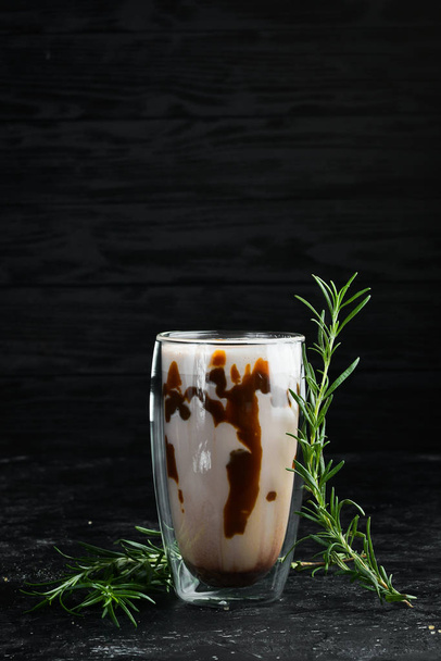 Cocoa with caramel and milk. In the glass. Top view. On a black background. - Фото, изображение