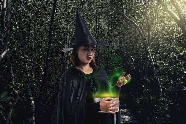 woman in Black Scary witch halloween costume holding spooky witc - Foto, Imagen