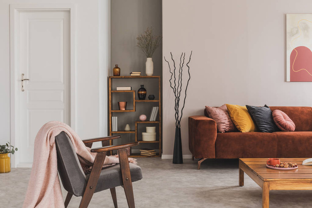 Grey vintage armchair with pastel pink blanket in elegant and atmospheric apartment - Zdjęcie, obraz