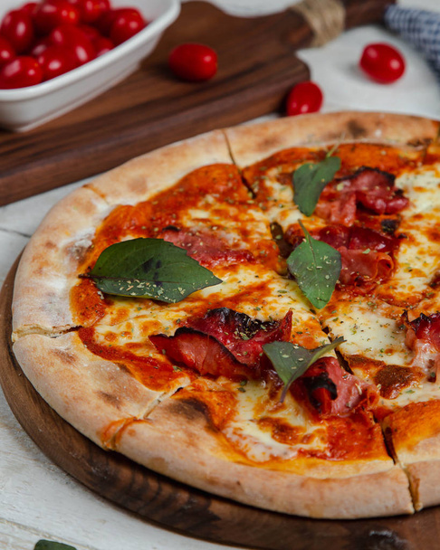 Sausage pizza topped with bay leaf - Foto, Bild